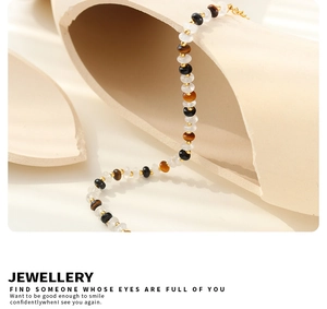 Vue macro d'un bracelet en jade blanc, onyx noir, oeil de tigre et perles dorées