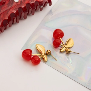 Detail shot of 18K gold plated stainless steel cherry drop earrings on a holographic card