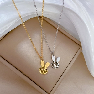 Gold and silver minimalist rabbit necklaces with Fu character pendants on silk fabric