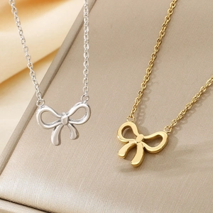 Minimalist stainless steel bow necklaces in gold and silver finish on display