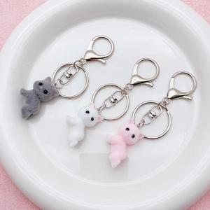 Three cute flocked cat keychains in grey white and pink with metal rings for bags