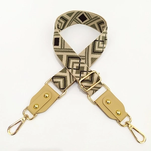 Detail of jacquard woven strap with geometric rhombus pattern and gold metal hardware