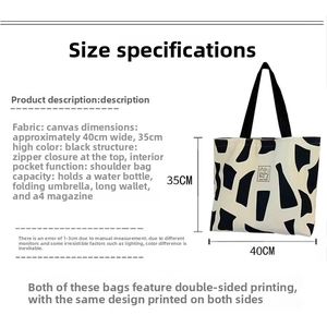 Detail of black canvas tote bag with abstract pattern, zipper closure and internal pocket