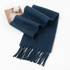 Deep blue cashmere wool scarf with elegant tassels on a minimalist white background