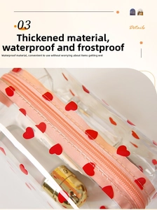 Detail of waterproof PVC makeup bag showing pink zipper and red heart patterns