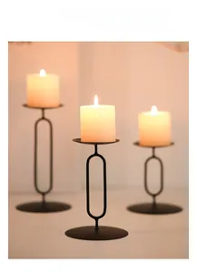 Detailed view of three black metal candle holders with matte finish on a dining table