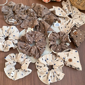 Detail of fabric scrunchies with polka dots, wooden buttons, and text labels on wood