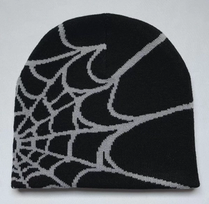 Detail of gray spider web jacquard pattern on a black knitted winter beanie hat