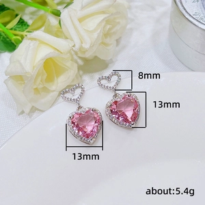 Elegant heart-shaped pink zircon earrings with small diamonds on white ceramic and rose