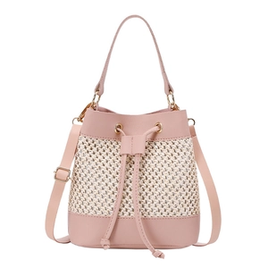 Detail of pink leather and woven straw bucket bag with gold hardware and drawstring