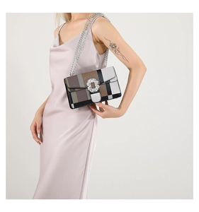 Detail of color-block crossbody bag with crystal buckle on model wearing pink dress