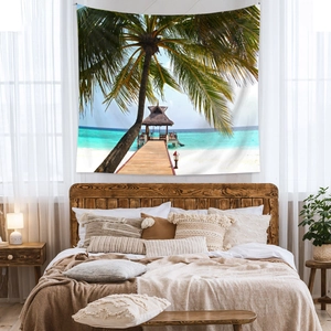 Détail d'une tapisserie bohème avec palmiers et plage accrochée au-dessus d'un lit