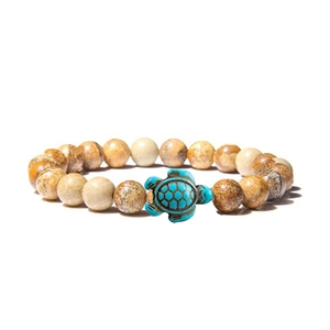 Macro detail of natural stone beaded bracelet with turquoise turtle centerpiece and earth tones