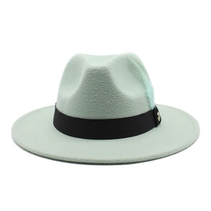 Détail d'un chapeau fedora vert menthe avec ruban noir et plume décorative sur le côté