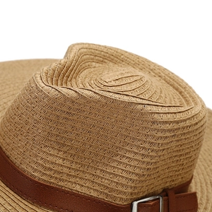 Detailed top view of light brown woven straw hat featuring a leather strap and silver buckle