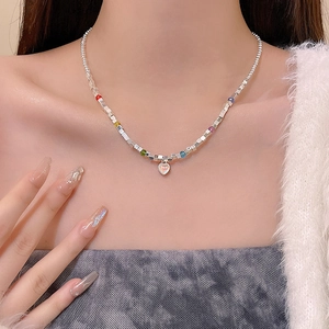 Close-up of butterfly heart pendant necklace with colorful beads on a female model