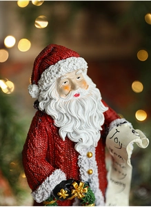 Close-up of resin Santa Claus figurine showing detailed knitted texture and Joy scroll