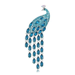 Detail of silver peacock brooch with blue crystals and elegant tassel fringe