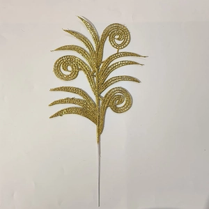 Close-up of golden glitter Christmas leaves with decorative spiral filigree patterns