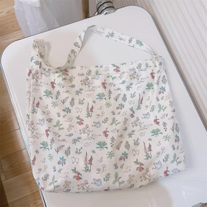 Detailed flat lay of cream cotton tote bag with woodland animals and floral print