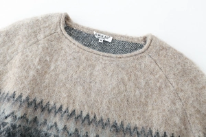 Close-up of fluffy jacquard knit sweater neck with zigzag pattern and brand label