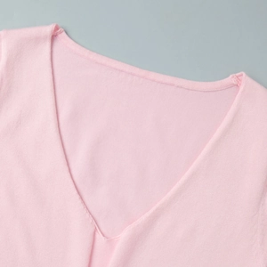 Detail of a pink knit V-neckline with smooth stitching and soft stretch fabric