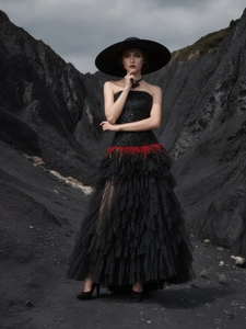 Elegant black sequined strapless evening gown with red feathers and layered tulle skirt