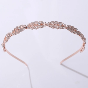 Close-up of rose gold metal headband with rhinestone leaf design for wedding hair