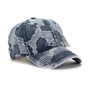 Détail d'une casquette en denim vintage avec des textures usées et des déchirures