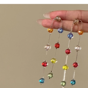 Detailed view of long tassel earrings with vibrant multi-colored glass beads.
