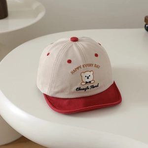 Gros plan détaillé de la broderie ours et des lettres sur la casquette bébé en coton