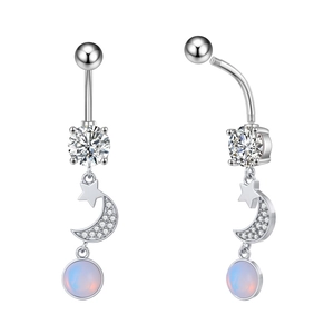Detailed view of silver navel piercing with moon and star pendants and blue opal