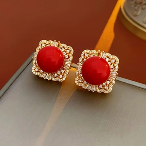 Detailed close-up of vintage square earrings with red pearl and zircon embellishments