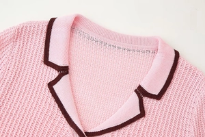 Detailed close-up of pink knit top collar with contrasting dark brown trim and texture