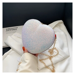 Detailed view of shimmering heart-shaped sequin mini bag with elegant gold chain strap