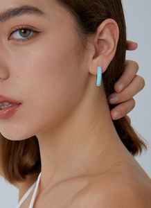 Close-up of a model wearing a sky blue C-shaped hoop earring with a sleek glazed finish
