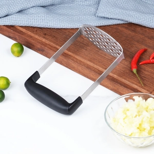 Presse-purée en acier inoxydable avec poignée ergonomique noire sur plan de travail
