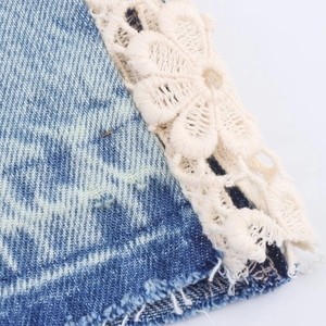 High-waist wide-leg jeans featuring blue denim and intricate cream lace patchwork details