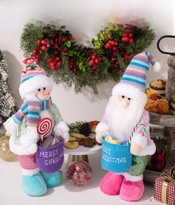 Close-up of plush Christmas snowman and Santa dolls with knitted hats and gift bags