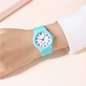 Close-up of mint green quartz watch with matte silicone strap and white numeric dial
