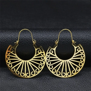 Bohemian hollow engraved gold fan earrings on black leather background from a top view