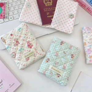 Close-up of quilted fabric passport holders with cute floral patterns and brand label
