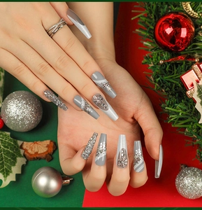 Gros plan d'ongles ballerine avec flocons 3D et paillettes dans un décor de Noël