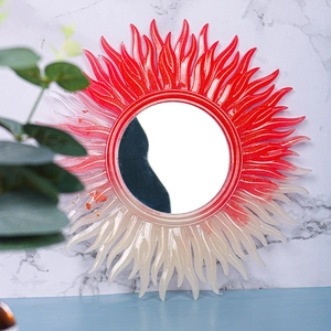 Detail of sunburst resin mirror frame with red-white gradient glitter finish and inner mirror