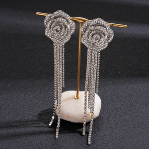 Detailed close-up of sparkling silver flower earrings with long diamond tassel fringes