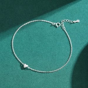 Minimalist S925 sterling silver heart bracelet on dark green textured surface
