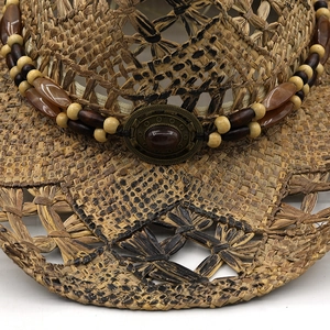Handmade woven straw cowboy hat with ethnic beaded band and bronze center medal