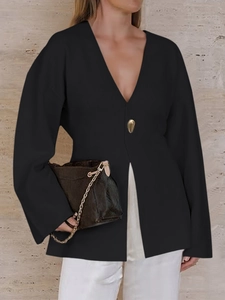 Detail of elegant black knitted cardigan with V-neck and a single gold button closure