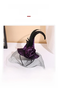 Detail of purple satin witch hat headband with black feathers and sheer mesh veil