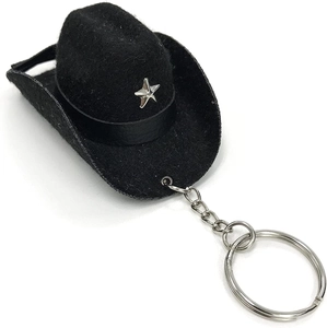 Close-up of a mini black cowboy hat keychain with a silver star and metal keyring